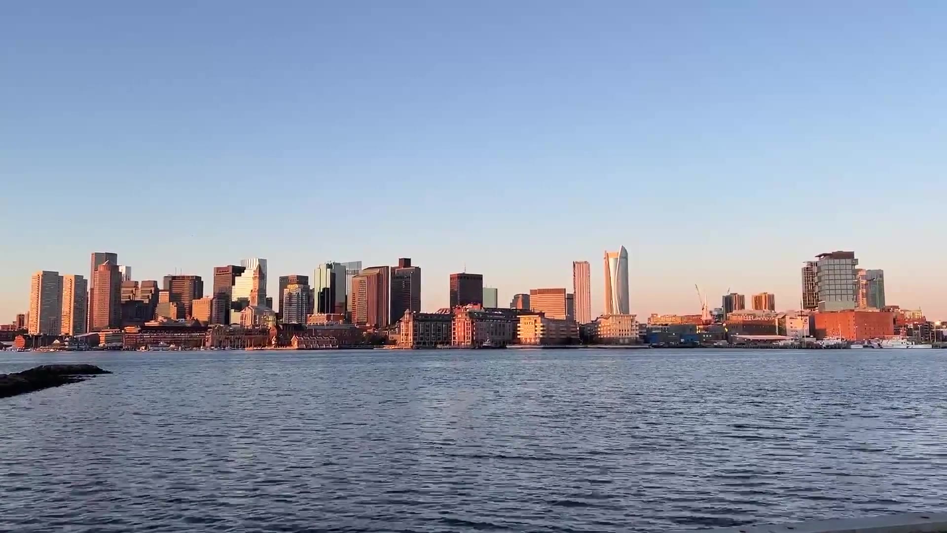 Boston skyline across the harbor at golden hour